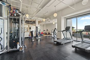 A gym with treadmills, weights, and exercise equipment.